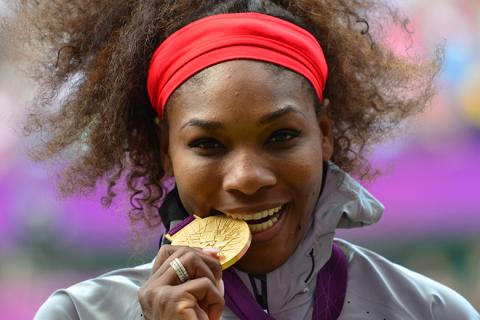 US Serena Williams poses on the podium with her gold medal after defeating Russia's Maria Sharapova in the women's singles gold medal match of the London 2012 Olympic Games, at the All England Tennis Club in Wimbledon, southwest London, on August 4, 2012. AFP PHOTO / LUIS ACOSTA (Photo credit should read LUIS ACOSTA/AFP/GettyImages)  