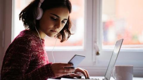 Student using laptop and phone